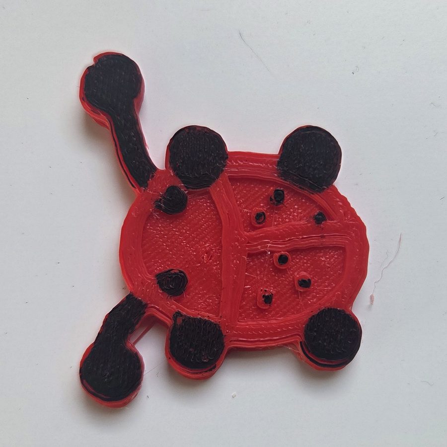 The finished red ladybug with black spots, legs and feelers painted on
