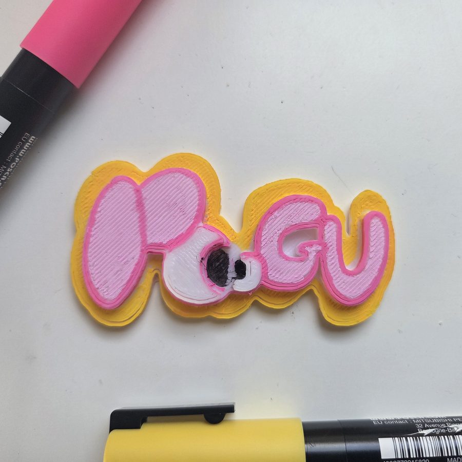A printed Poogu logo coloured in with yellow and pink paint pens